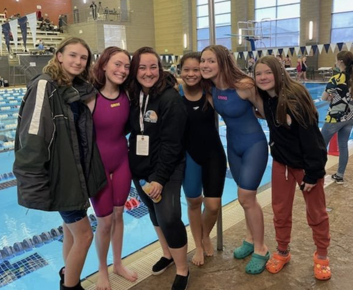 girls swim team at side of pool