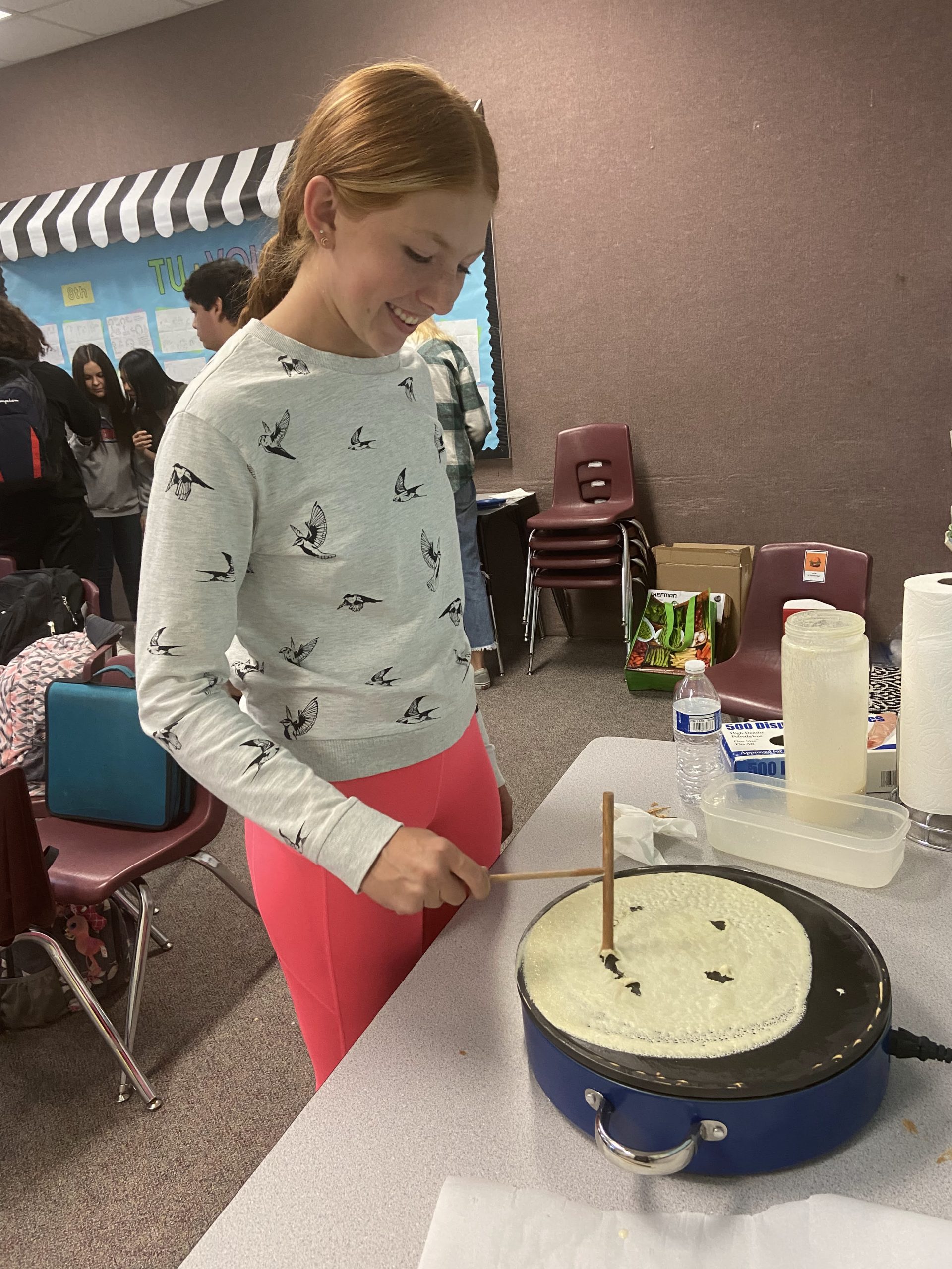 student making smiley face with a crepe